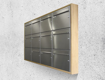 Silberne Briefkastenanlage auf Betonfront
